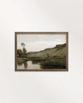Muted riverside landscape wall art printable with rolling hills, trees and still water