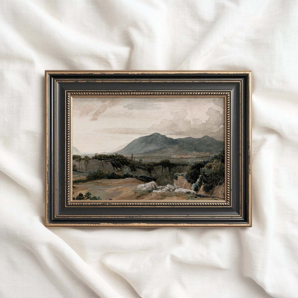 Western landscape art featuring distant mountains, rugged terrain and a soft cloudy sky